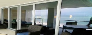Storm doors on a beachfront balcony, featuring impact-resistant glass