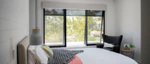 Luxary Bedroom having white interior installing big Windows on the wall  