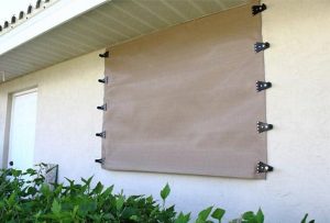 A hurricane protection screen over a window.