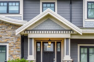 Front of a well built house with varying siding work.