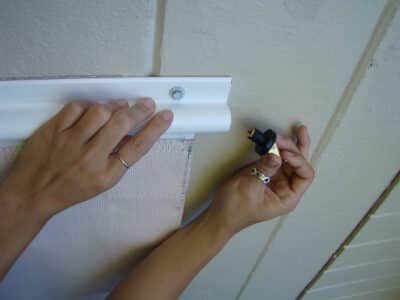 A close-up view of a Florida homeowner deploying their slide screen