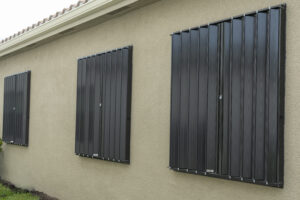 Black accordion shutters on a beige home
