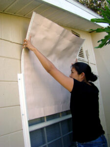 Woman installing a protective easy screen on her window