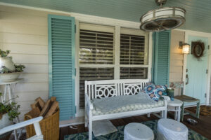 Home with teal shutters on porch windows